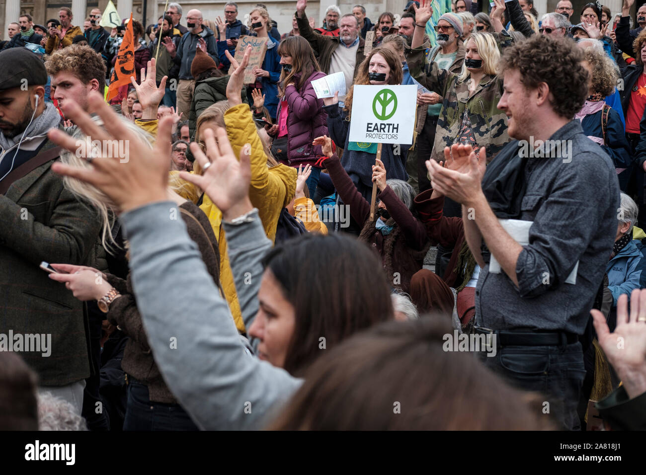 Extinción rebelión activistas con cinta adhesiva sobre su boca cuando se reunieron en Trafalgar Square para protestar por la prohibición de la policía Foto de stock