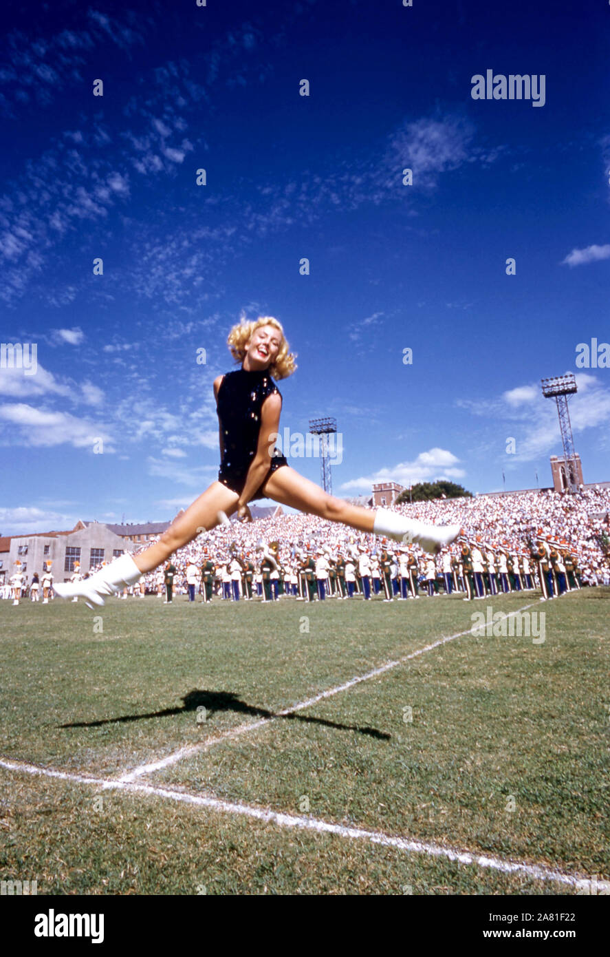 ATLANTA, GA - 17 DE SEPTIEMBRE: UNA porra twirler bailes en el campo como los Huracanes de Miami band realiza durante el descanso entre un juego de NCAA con los Huracanes de Miami y Georgia Tech Yellow Jackets, el 17 de septiembre de 1955 en el Grant Field en la ciudad de Atlanta, Georgia. Los Yellow Jackets derrotaron a los huracanes 14-6. (Foto por Hy Peskin) (número de registro: X3090) Foto de stock