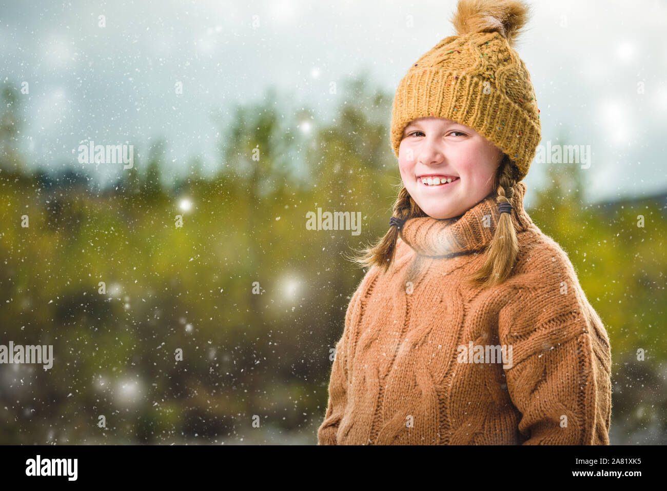 Hermosa chica rubia en un suéter de lana y una gorra. Hermoso paisaje otoñal con un río en el fondo. Foto de stock