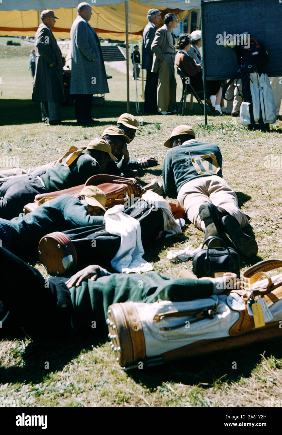 AUGUSTA, GA - marzo de 1956: African American caddies resto con bolsas de golf club durante un evento de golf en el Augusta Country Club alrededor de marzo de 1956 en Augusta, Georgia. (Foto por Hy Peskin) Foto de stock