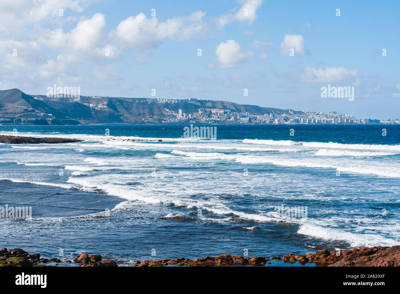 Playa con olas con Las Palmas de Gran Canaria en el fondo Fotografía de  stock - Alamy