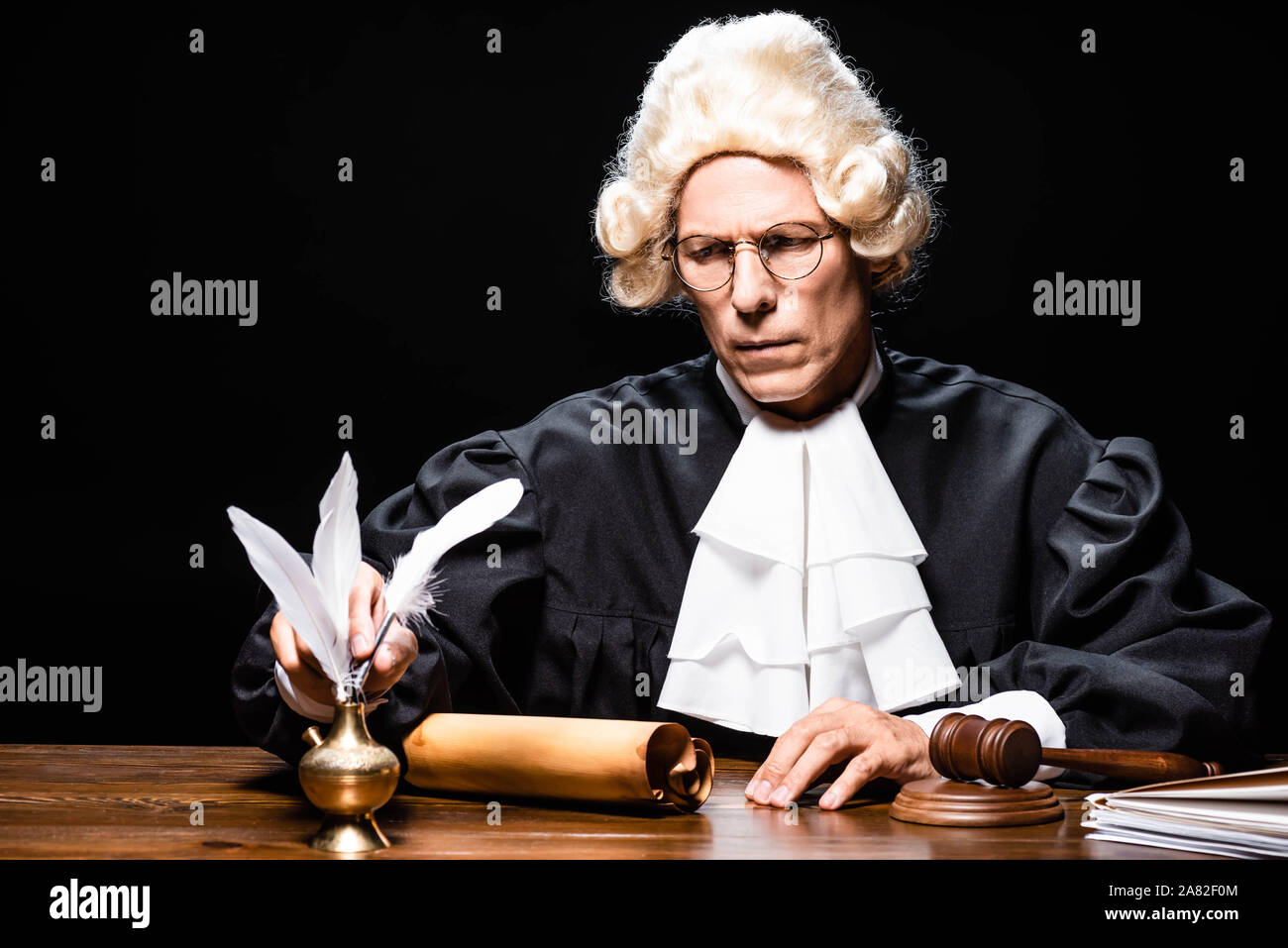 Juez de túnica judicial y la peluca teniendo feather aislados en negro  Fotografía de stock - Alamy