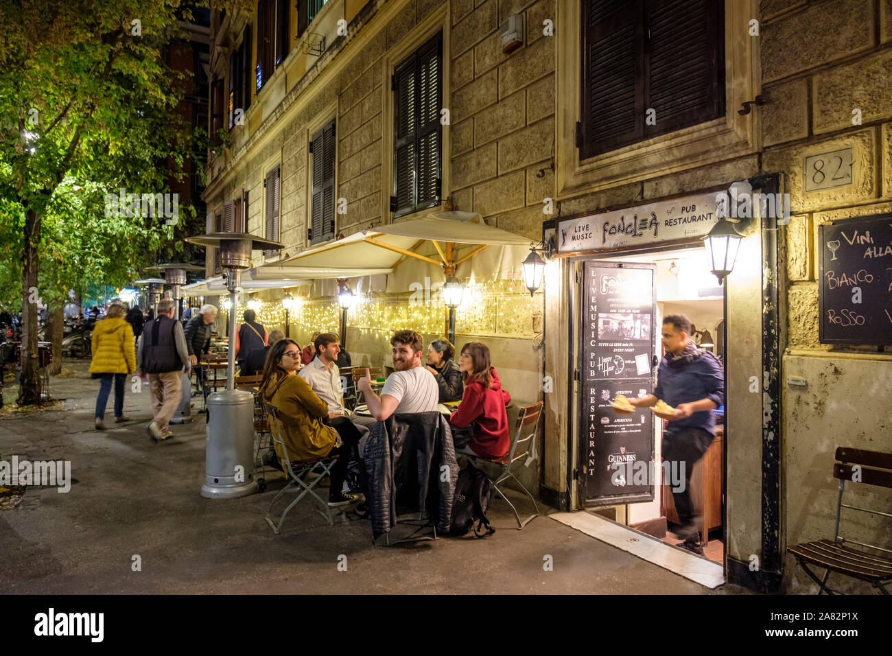 Comidas al aire libre, clientes sentados en la acera fuera del restaurante Fonclea SRL, pub tradicional con música en vivo, barrio Prati, Roma, Italia Foto de stock