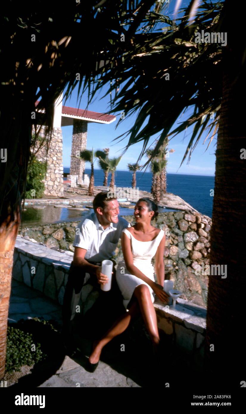 BAJA CALIFORNIA, MÉXICO - JUNIO DE 1962: el actor y ex jugador de béisbol Chuck Connors (1921-1992) y la actriz prometido Kamala Devi (1934-2010) sentarse fuera en el Cabo San Lucas Hotel durante un viaje de pesca alrededor de junio de 1962, en Baja California, México. (Foto por Hy Peskin/Getty Images) (número de registro: X8569) *** Local Caption *** Kamala Devi;Chuck Connors Foto de stock