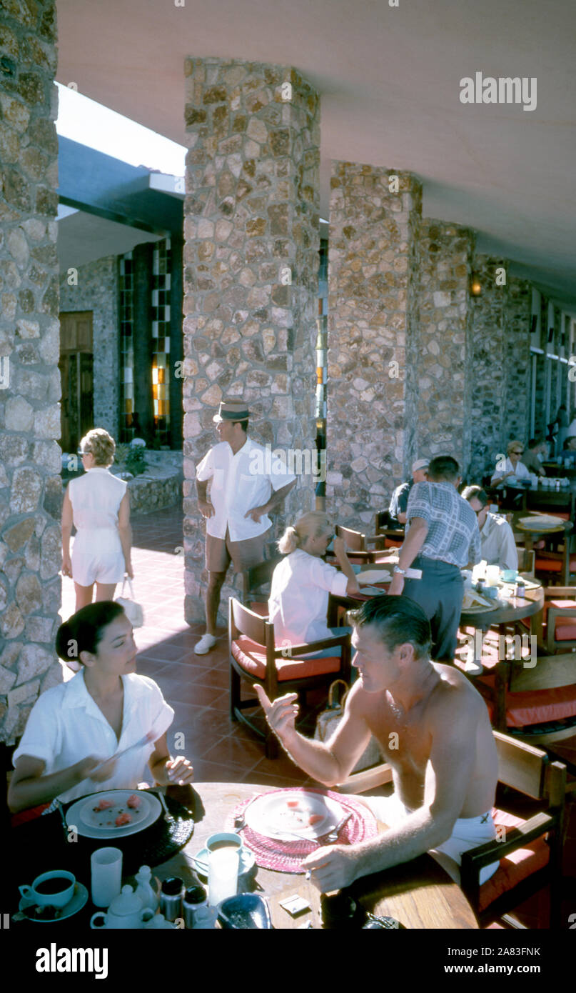 BAJA CALIFORNIA, MÉXICO - JUNIO DE 1962: el actor y ex jugador de béisbol Chuck Connors (1921-1992) y la actriz prometido Kamala Devi (1934-2010) desayunar afuera en el Cabo San Lucas Hotel durante un viaje de pesca alrededor de junio de 1962, en Baja California, México. (Foto por Hy Peskin) (número de registro: X8569) *** Local Caption *** Kamala Devi;Chuck Connors Foto de stock