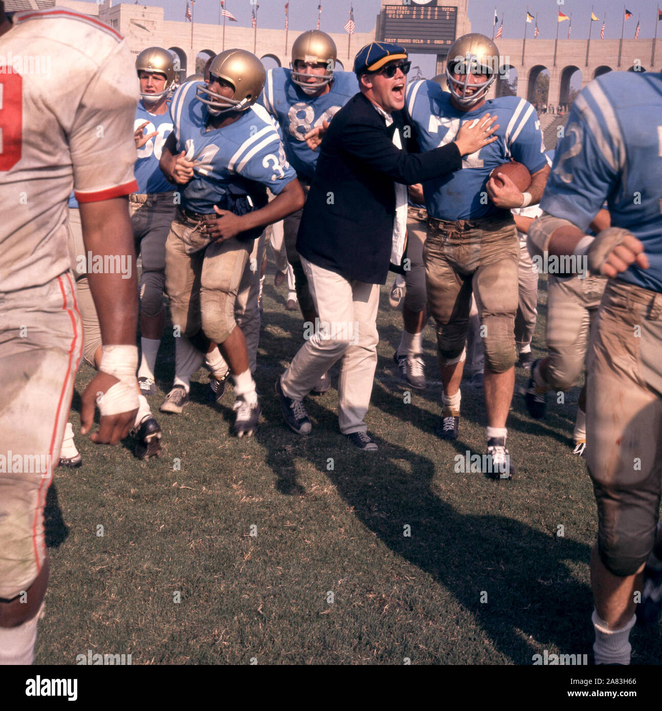 LOS ANGELES, CA - 6 de octubre: Warren Jackson #34 y Phil Oram #77 de la UCLA Bruins celebrar con un ventilador tras derrotar a los Ohio State Buckeyes después de un partido de NCAA en Octubre 6, 1962 en el Los Angeles Memorial Coliseum en Los Angeles, California. (Foto por Hy Peskin) (número de registro: X8760) *** Local Caption *** Warren Jackson;Phil Oram Foto de stock