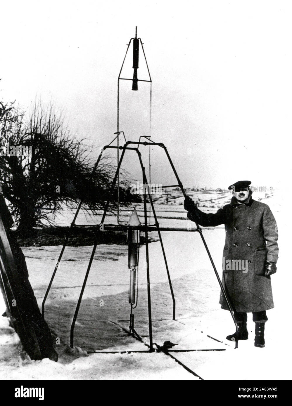 El Dr. Robert H. Goddard y un cohete de gasolina de oxígeno líquido en el fotograma desde el que se disparó el 16 de marzo de 1926, en Auburn, Massachusetts. Foto de stock