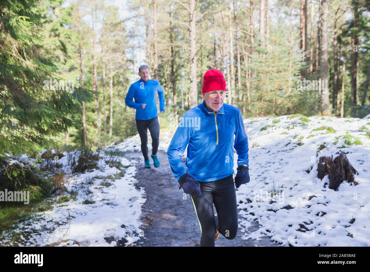 El padre y el hijo en sendero de jogging en Snowy Woods Foto de stock
