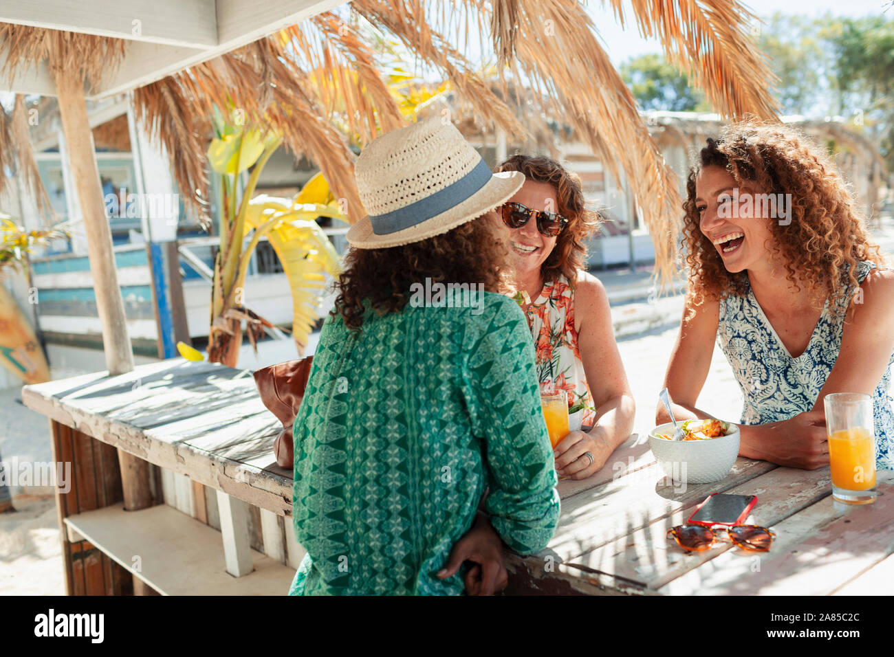 Las mujeres feliz desayunando en sunny beach bar Foto de stock