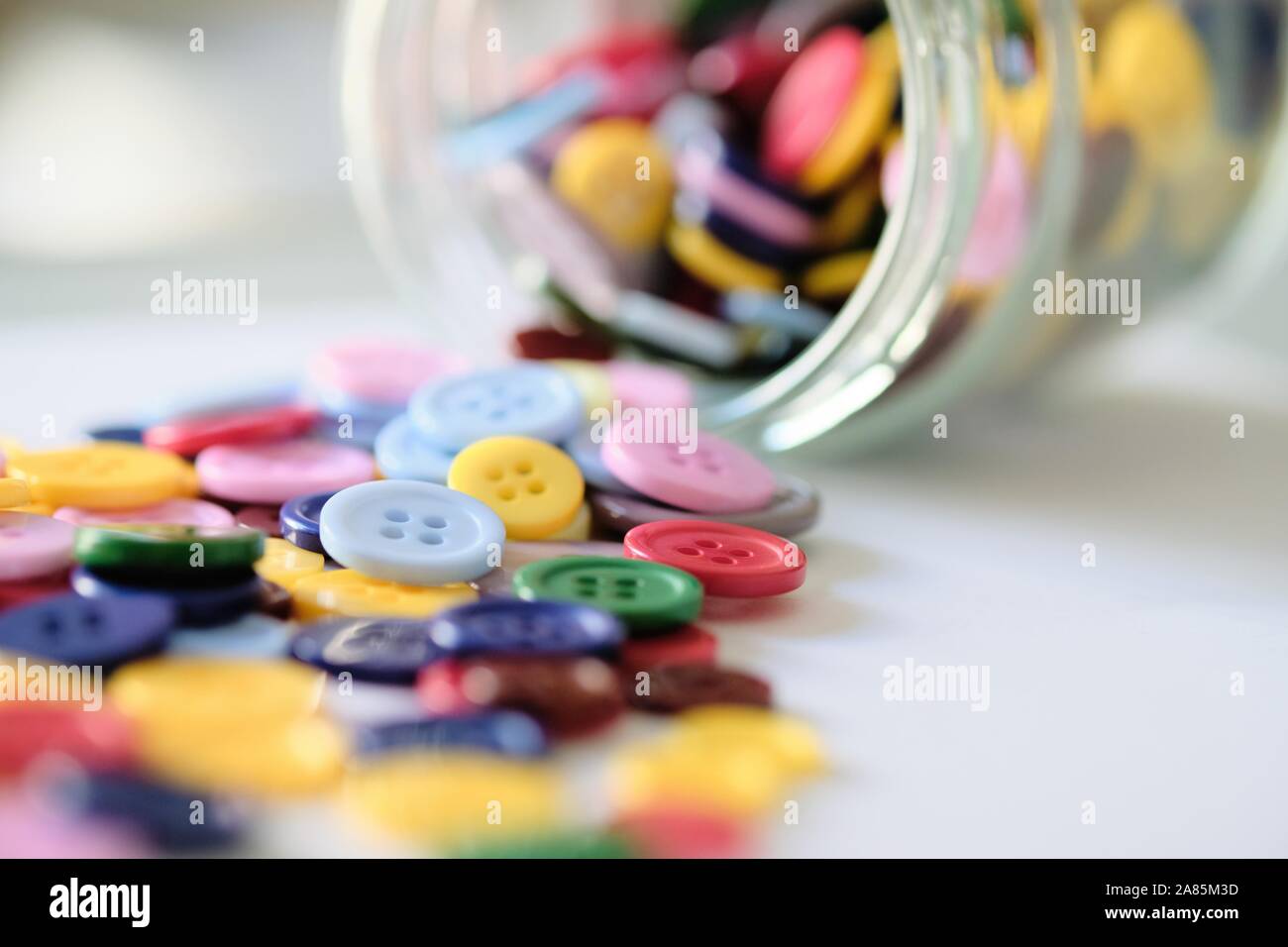 Gran grupo de coloridos cosiendo botones de plástico en una lata en la mesa, con espacio para copiar texto Foto de stock