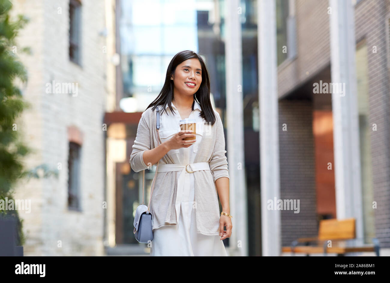 Café para llevar. mujer de moda joven en ropa de verano de moda sosteniendo  la taza de café mientras camina por la ciudad
