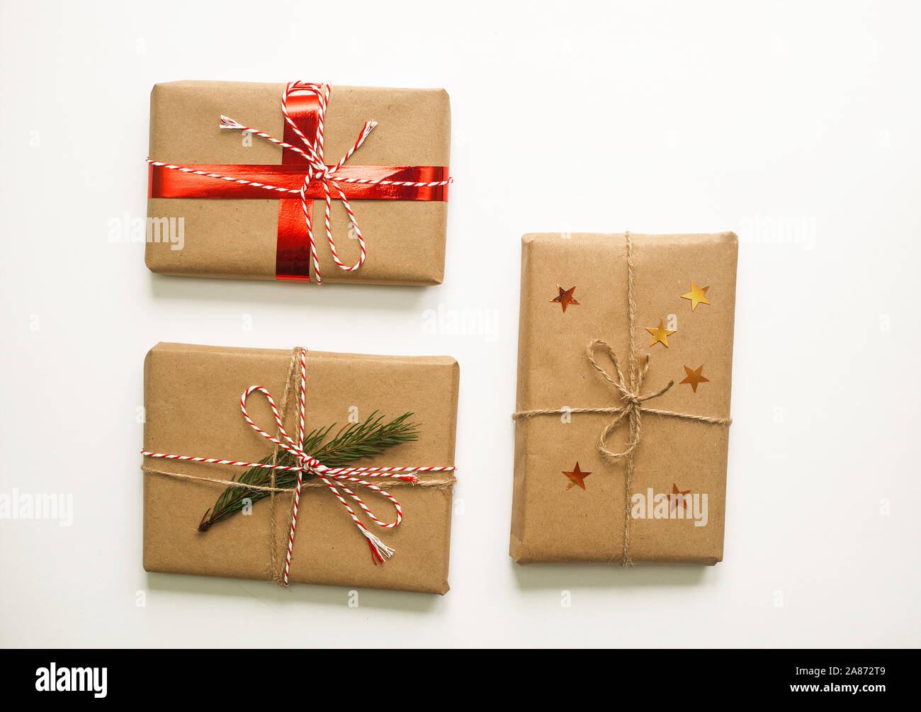Regalo de Navidad vacaciones cajas decoradas con cintas y pino rojo sobre  fondo blanco. Conjunto de tres objetos de diseño. Papel Artesanal, DÉVÉNYI  Fotografía de stock - Alamy