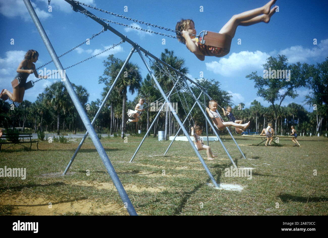 1954: Los niños swing en un columpio en su patio de recreo en 1954. (Foto por Hy Peskin) Foto de stock