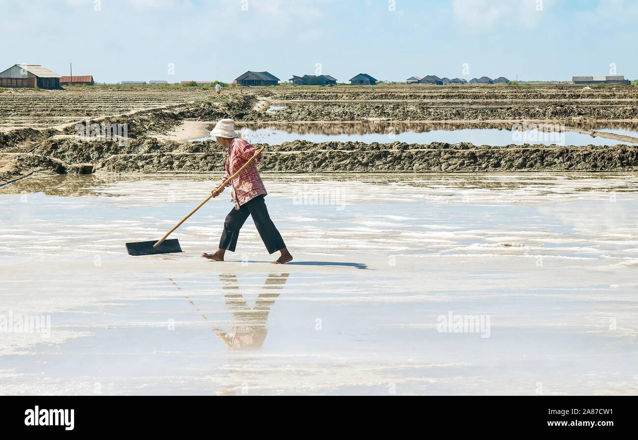 La provincia de Kampot, Camboya - Marzo 6, 2012. Una mujer camboyana cosechas trabajador sal marina de uno de los varios campos en una granja que produce sal de e Foto de stock