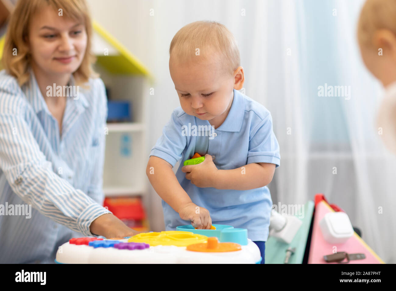 Cute little boy kid jugar con juguetes en grupo de cría de kindergarten Foto de stock
