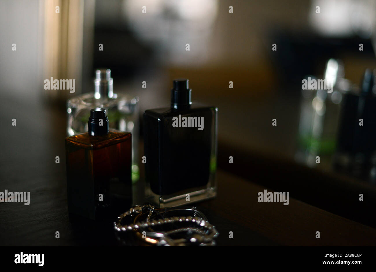 Tres frascos de perfume por un espejo Foto de stock