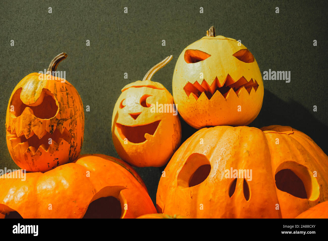 Halloween calabazas talladas sobre fondo verde. Concepto de Halloween: montón de Jack O'Lantern calabazas con caras tenebrosas Fotografía de stock - Alamy Halloween calabazas talladas sobre fondo verde. Concepto de Halloween: montón de Jack O'Lantern calabazas con caras tenebrosas Fotografía de stock - Alamy