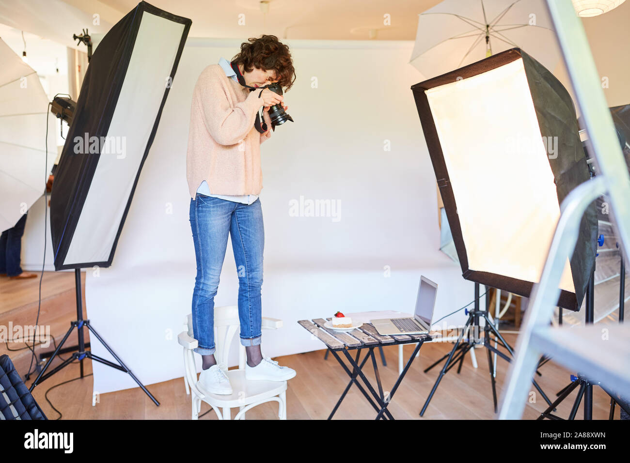 Joven fotógrafo está de pie en una silla y fotografiar los alimentos  Fotografía de stock - Alamy