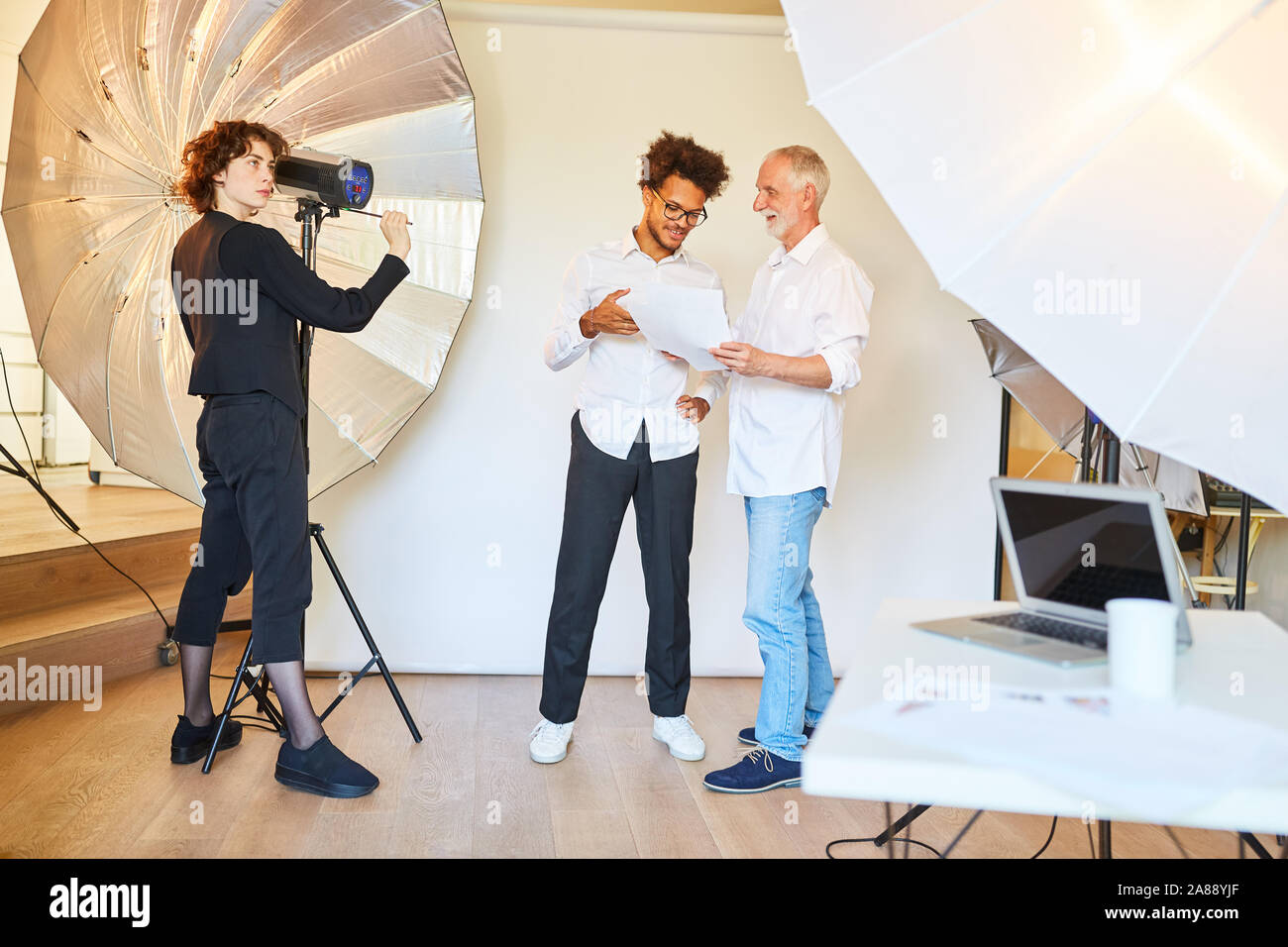 Fotógrafo con el director de arte y ayudante de fotografía en la  preparación de un estudio fotográfico photo shoot Fotografía de stock -  Alamy