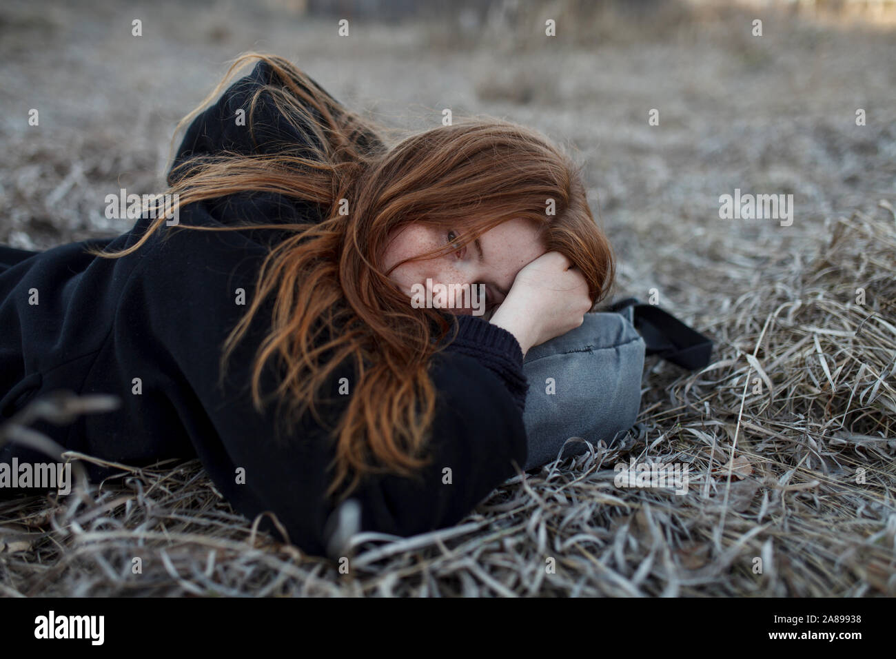 Niña adolescente acostada en una bolsa en el campo Foto de stock