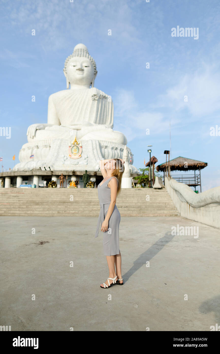 Joven turista concreto de pie cerca de la estatua de Buda en Phuket. Foto de stock