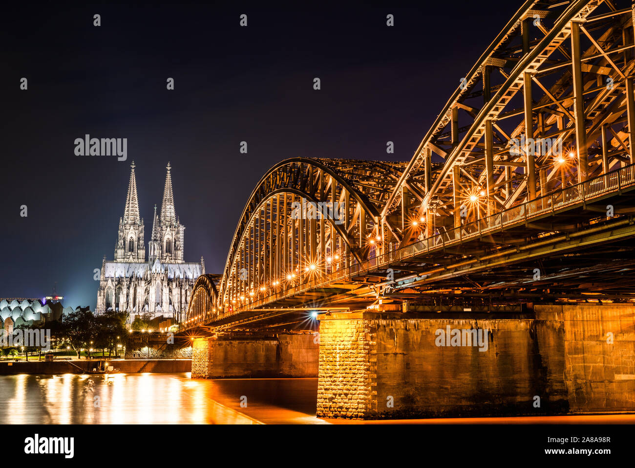 Colonia de noche con la catedral de Colonia, el puente Hohenzollern y el río Rin. Foto de stock