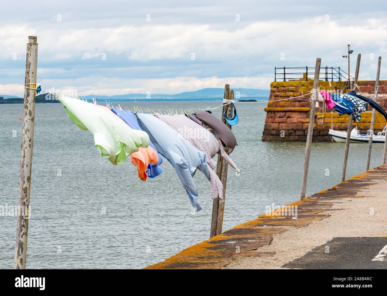 Ropa colgada en una línea de lavado en un día ventoso en el mar de Firth of Forth, Berwick del Norte, East Lothian, Escocia, Reino Unido Foto de stock