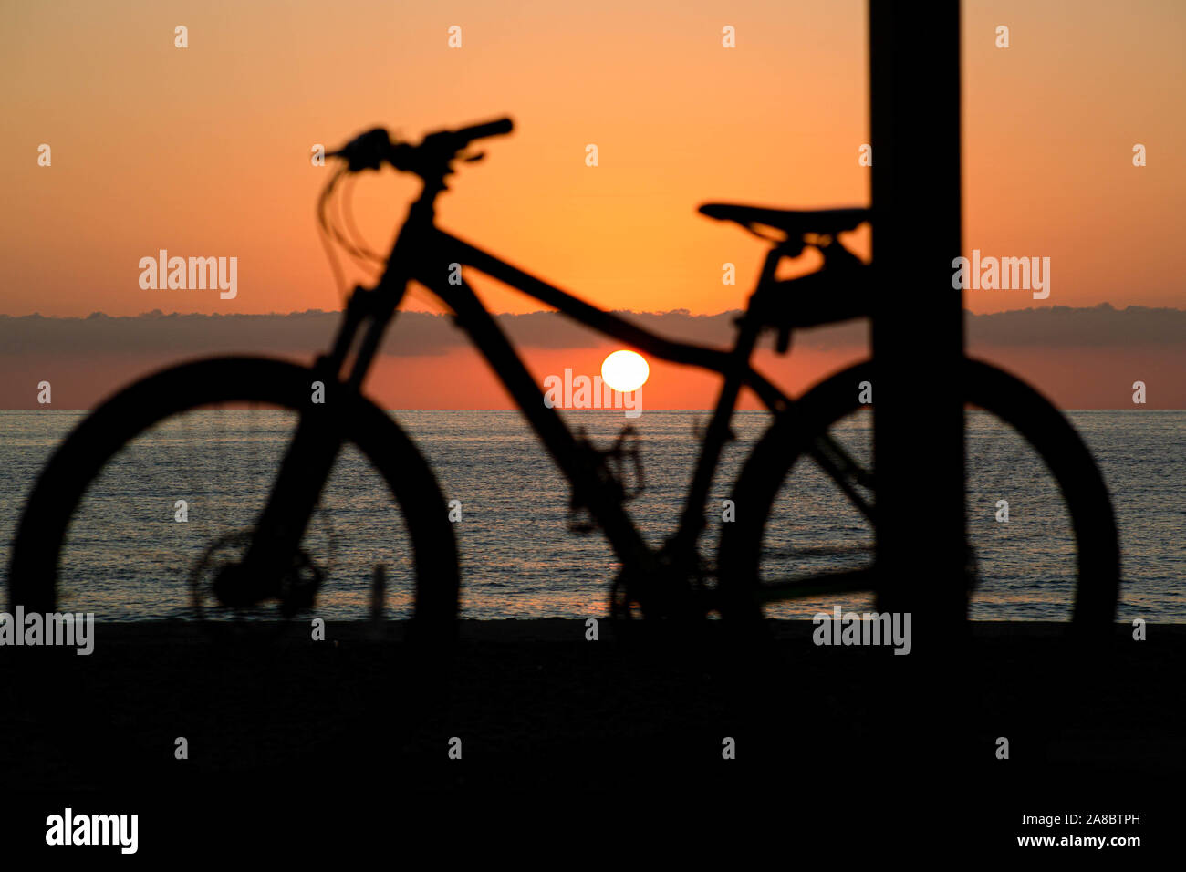 La moto en la playa al amanecer Foto de stock