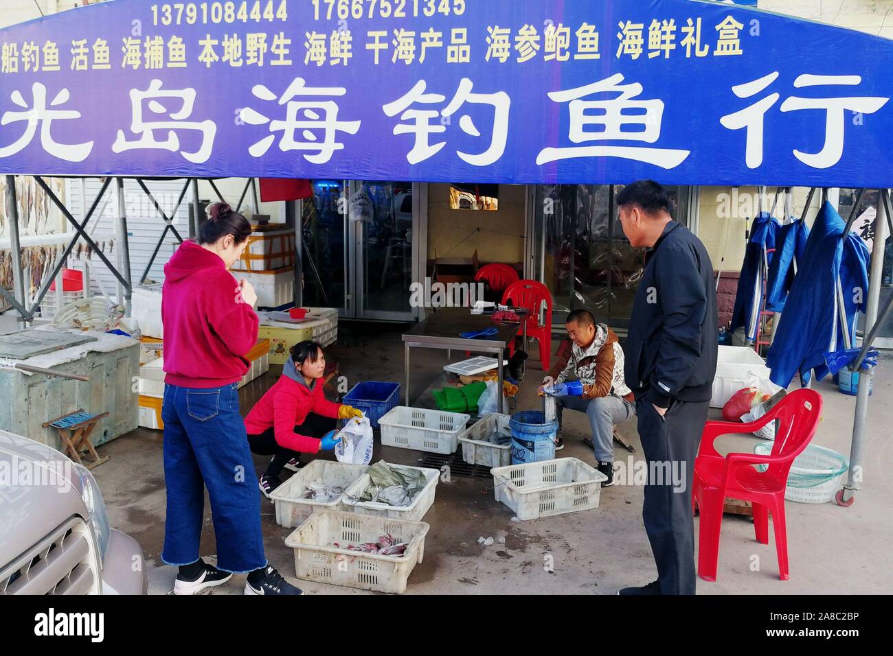 Shandong, Shandong, China. 8 nov, 2019. Shandong, China-pescadores cuelga el pescado seco en el mercado del puerto pesquero Jimiya en Qingdao, Provincia de Shandong, en el este de China, el 7 de noviembre, 2018.secar el pescado a finales de otoño y principios de invierno es una tradición de pescadores en la península de Jiaodong.Pescadores seleccione primero el pescado fresco del mar, corte la espalda y espolvorear las capas de sal gruesa, luego agregar la sal durante un corto periodo de tiempo, alrededor de una hora y, a continuación, enjuague con agua limpia.Por último, la difusión en la red de pesca o colgarlos para que se sequen. Cuando son 70% secas pueden ser comidos. Crédito: SIPA Asia/Zuma alambre/Alamy Live News Foto de stock