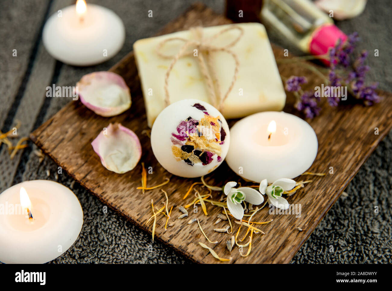 Diversos productos de baño spa en bandeja de madera marrón cremoso jabón natural bomba de baño, bar con hilo de algodón, pétalos de flores secas, spa, velas encendidas, esencial Fotografía de stock - Diversos productos de baño spa en bandeja de madera marrón cremoso jabón natural bomba de baño, bar con hilo de algodón, pétalos de flores secas, spa, velas encendidas, esencial Fotografía de stock -