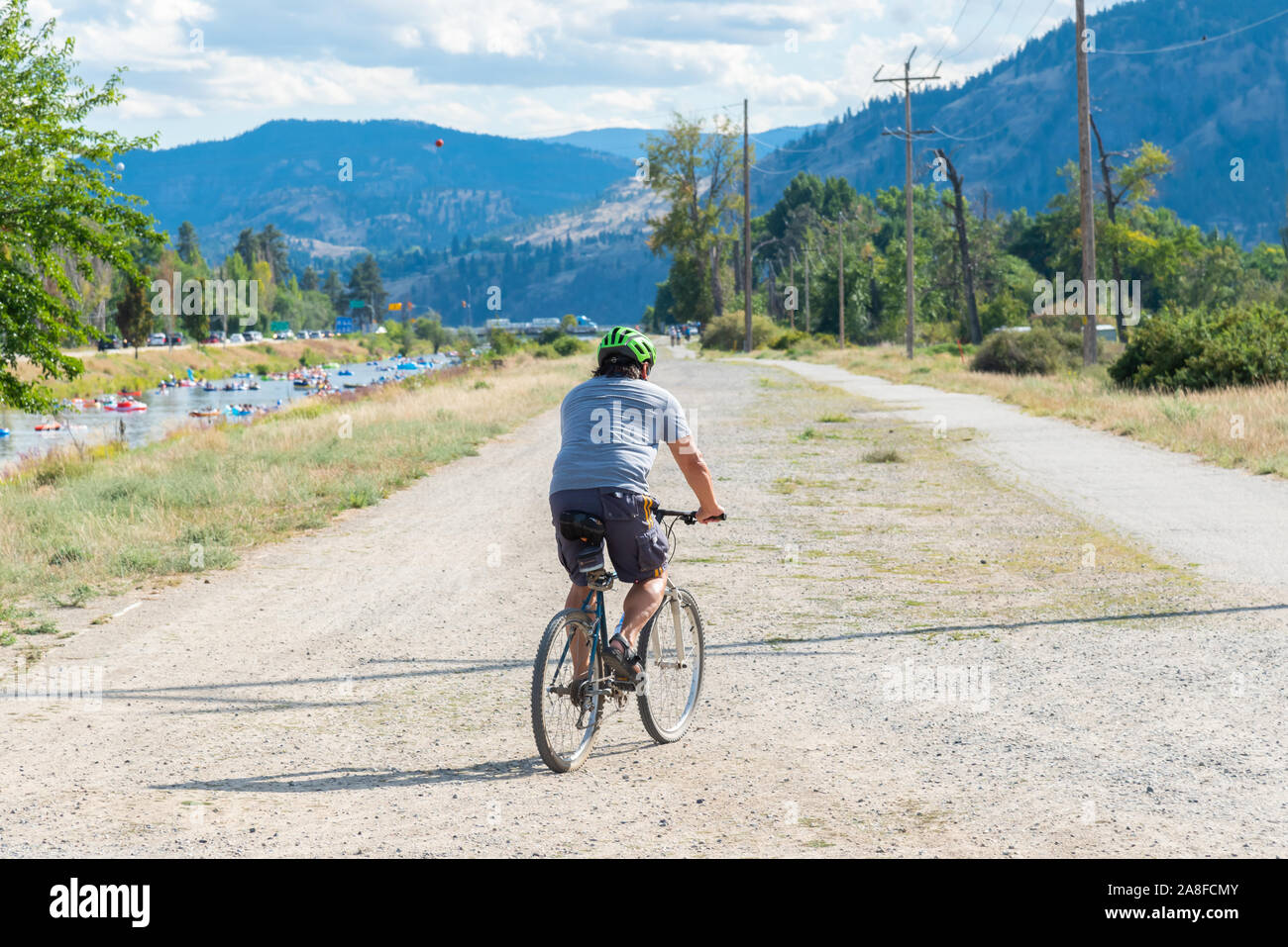 Penticton, British Columbia/Canadá - 1 de septiembre de 2019: el hombre de los paseos en bicicleta a lo largo del canal del río Penticton Trail, una ruta popular Foto de stock
