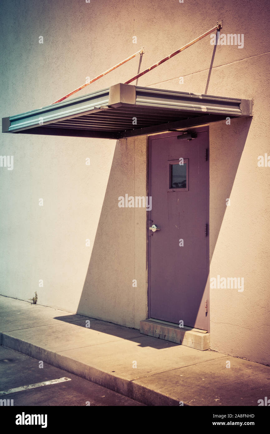 Un sentir minimalista a una puerta sin marcar la entrada a un edificio de  diseño industrial moderno con toldo rígido pendiente sobre la puerta en los  EE.UU Fotografía de stock - Alamy