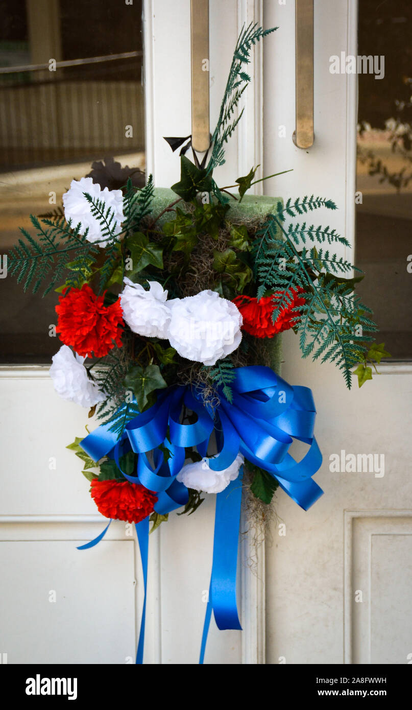 Un luto ramo de rojo, blanco y azul claveles en puerta delantera simboliza la simpatía por los miembros de la familia del difunto en la pequeña ciudad de América, EE.UU. Foto de stock