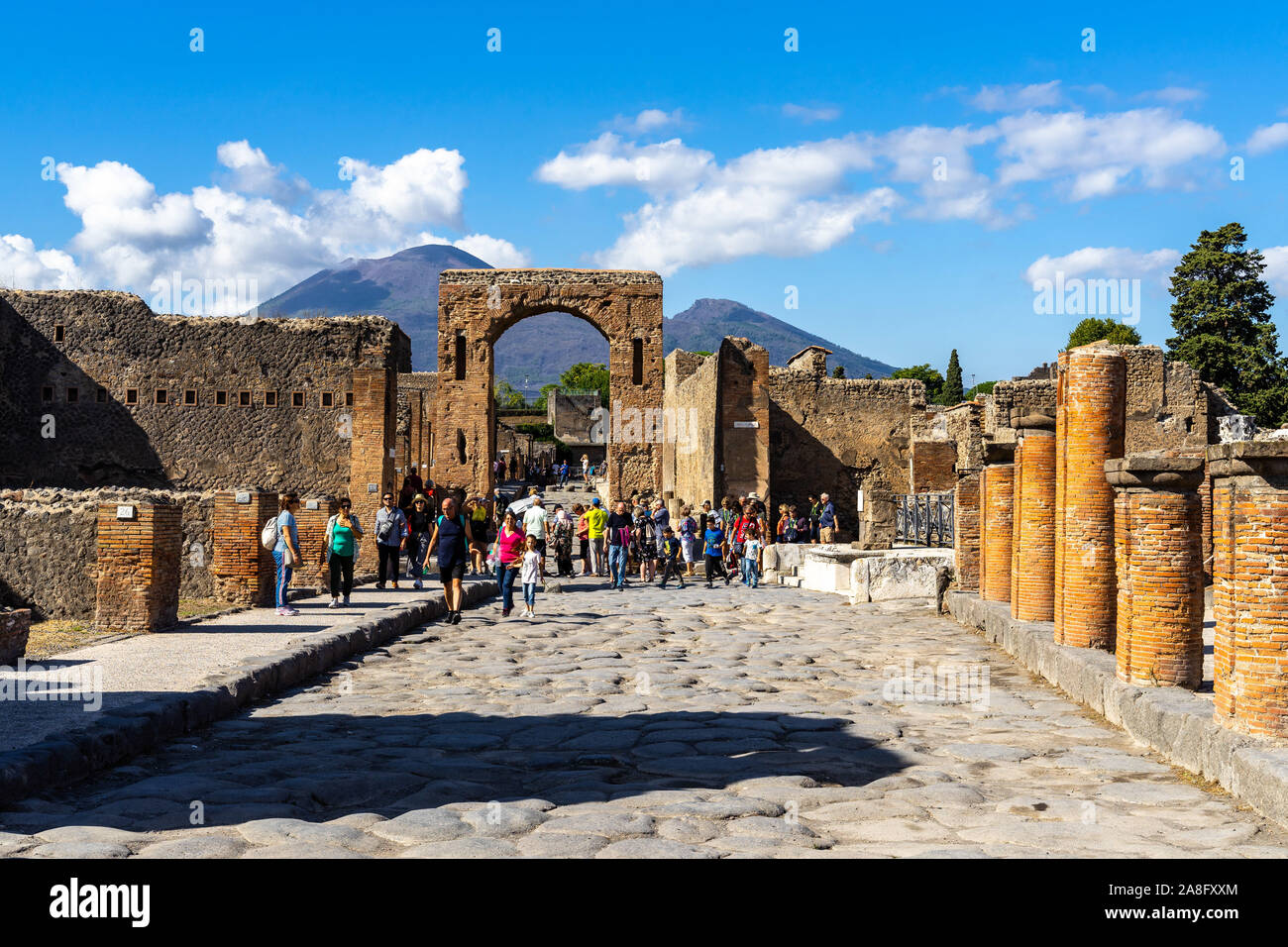 Vista de la via del Foro en la antigua ciudad de Pompeya con el arco de Calígula y el Monte Vesubio en el fondo. Pompeya, Italia, en octubre de 2019 Foto de stock