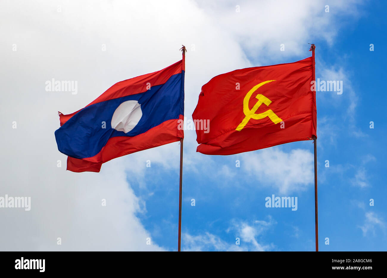 La Bandera Nacional de Laos con la bandera roja con símbolos comunistas de  una hoz con un martillo volando en un cielo azul, Laos Fotografía de stock  - Alamy