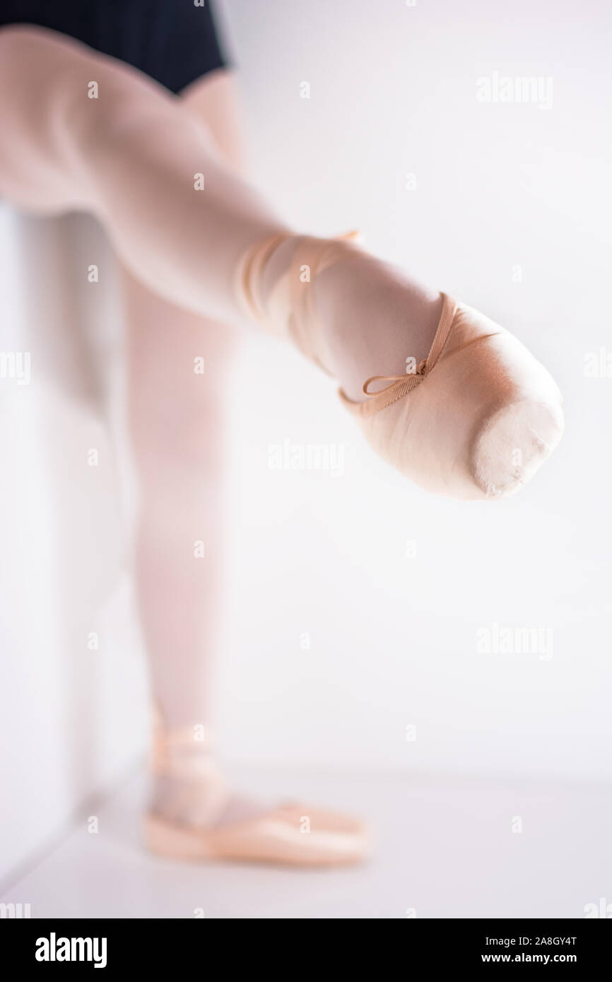 Detalle de la punta de un zapato de ballet para bailar ballet con una bailarina posando con una pierna levantada Foto de stock