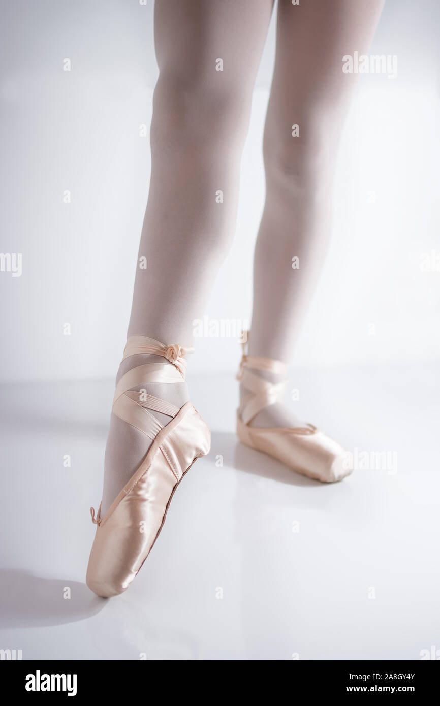 Detalle de las piernas y los pies con zapatos de pointe de satén rosado por un bailarín clásico posando Foto de stock
