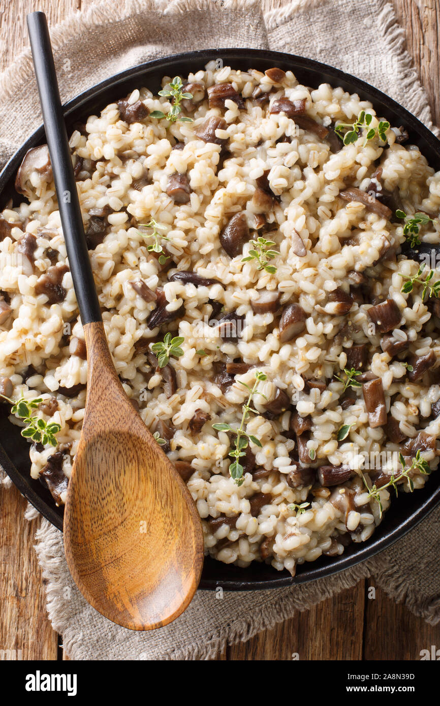 Orsotto receta de cebada perlada con bosque setas porcini y tomillo closeup  sobre un plato en la mesa. Vista superior de la vertical desde arriba  Fotografía de stock - Alamy