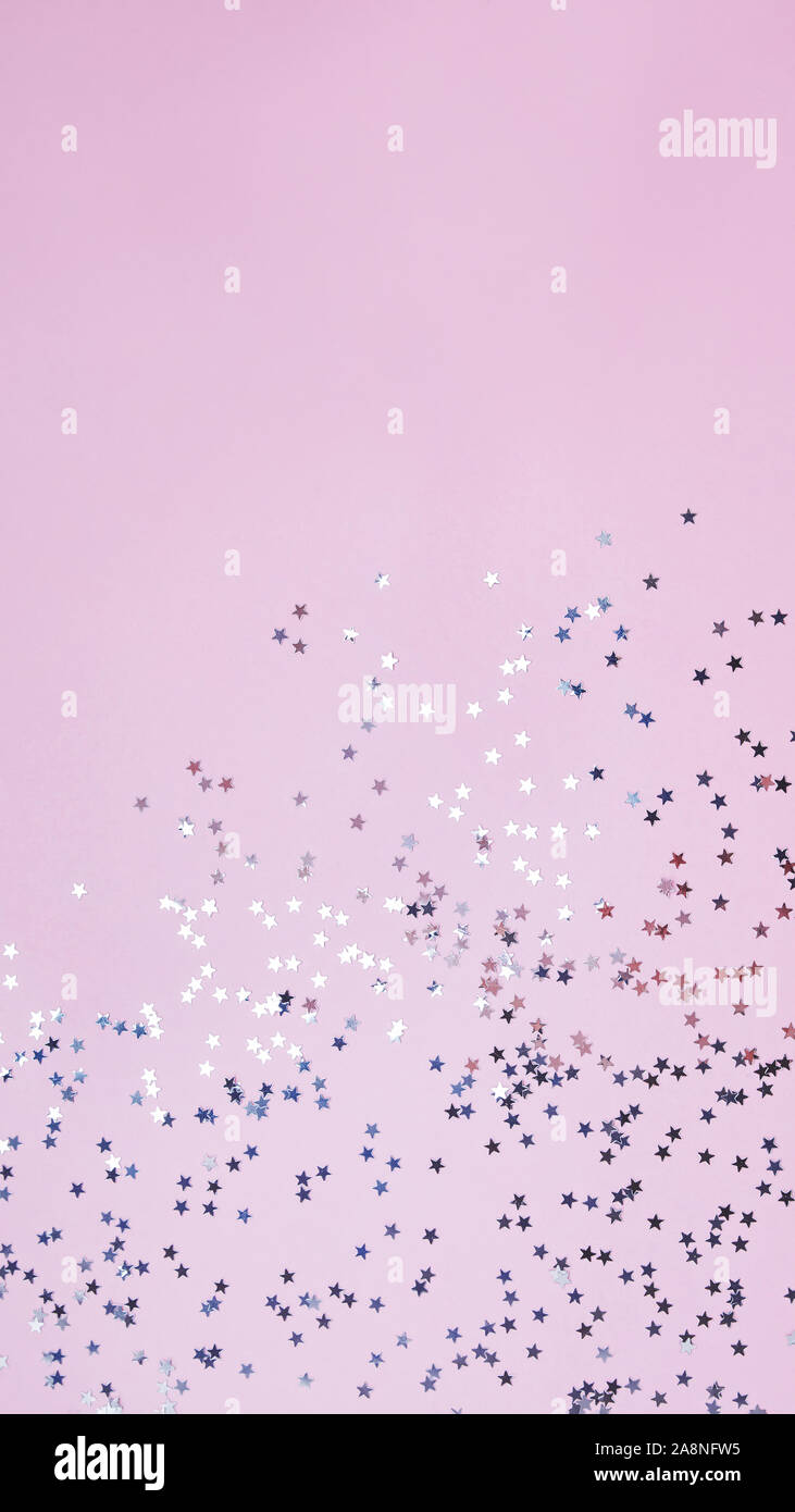 Confeti en forma de estrella sobre fondo de color rosa pastel Fotografía de  stock - Alamy