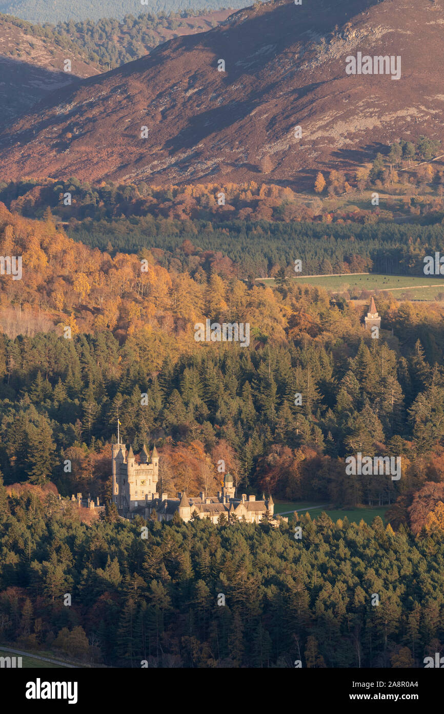 El castillo de Balmoral y Crathie Iglesia oculta por árboles en esta vista otoñal del Parque Nacional de Cairngorms Foto de stock