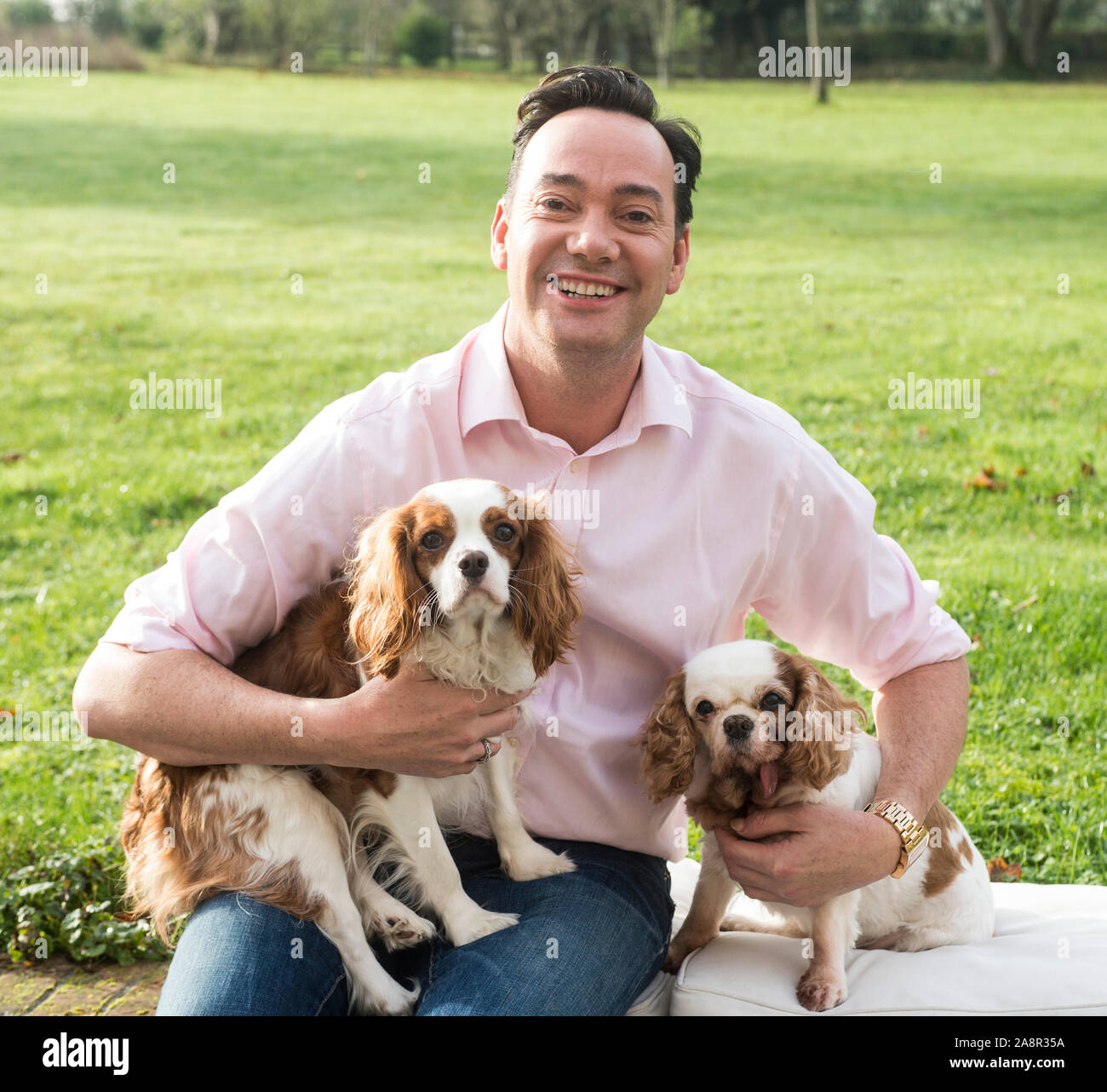 Estrictamente come dancing juez Craig Revel Horwood con sus dos King Charles épagneuls perros de rescate Sophie y Charlie en su casa Andover en Hampshire. Foto de stock