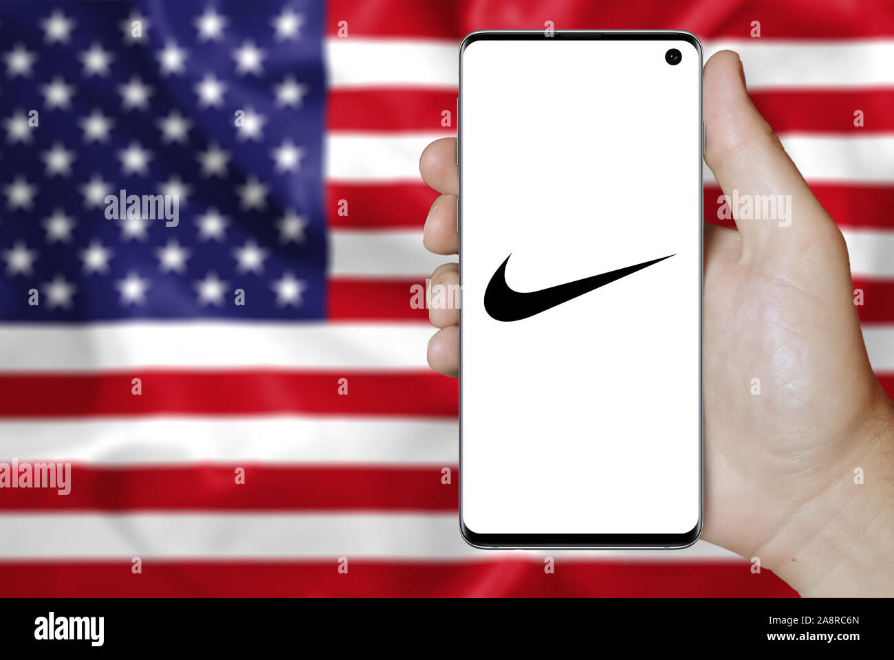 Logotipo de empresa pública Nike aparece en un smartphone. La bandera de  EE.UU. Antecedentes. Crédito: PIXDUCE Fotografía de stock - Alamy