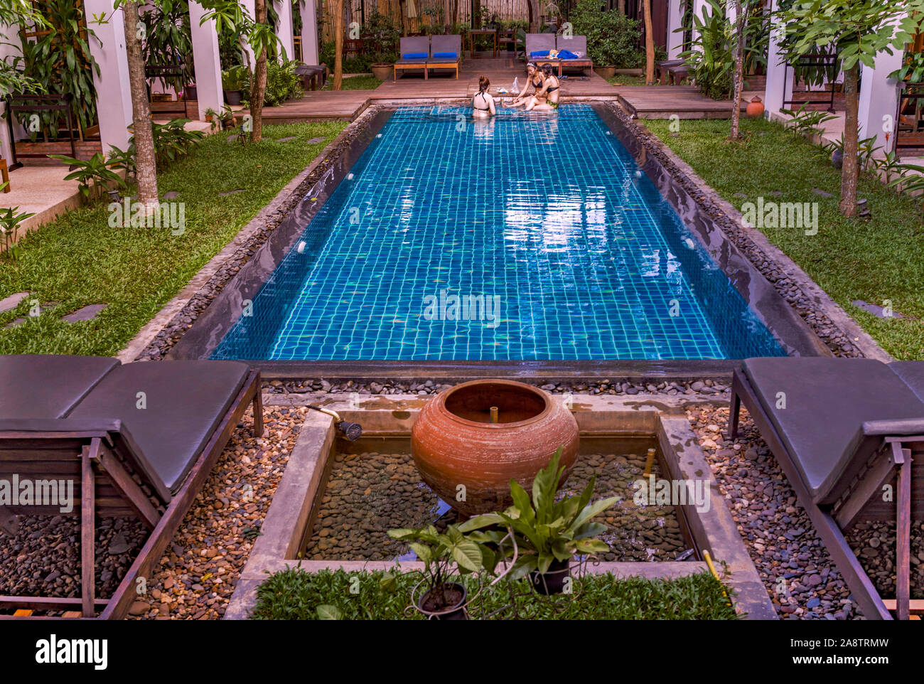Al lado de la piscina de un hotel con encanto, boutique y de lujo en la lista de Patrimonio Mundial de la UNESCO, la ciudad de Luang Prabang, en Laos, Sudeste de Asia Foto de stock
