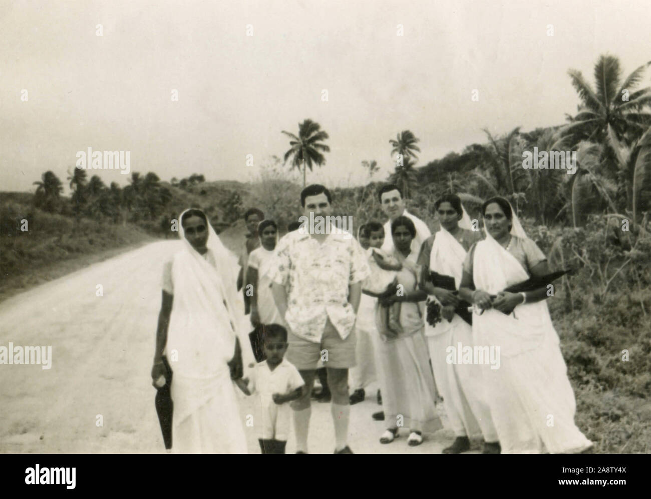 Los turistas occidentales con un grupo de lugareños, Fiji 1940 Foto de stock