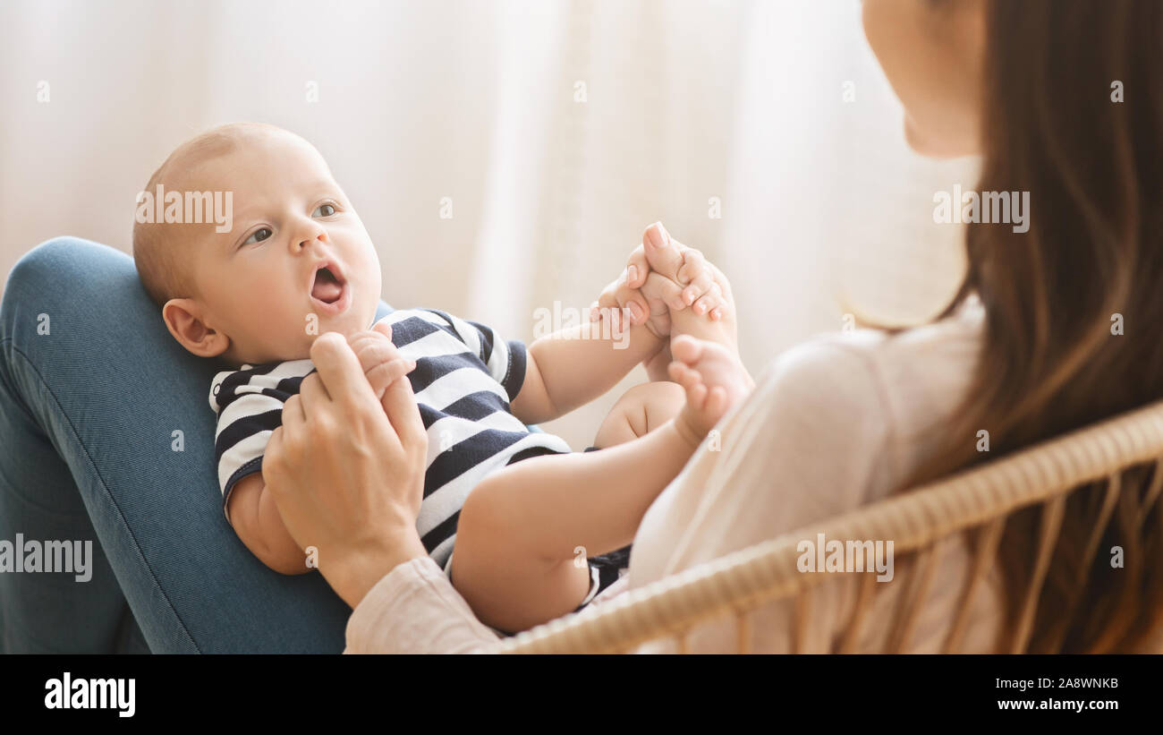 Adorable bebé recién nacido arrullo mientras yace en el regazo de la madre  Fotografía de stock - Alamy