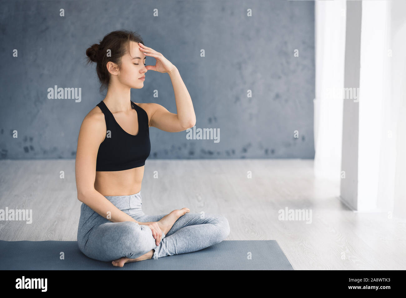Mujer joven practicando yoga, técnica de respiración Nostril alternativo Foto de stock