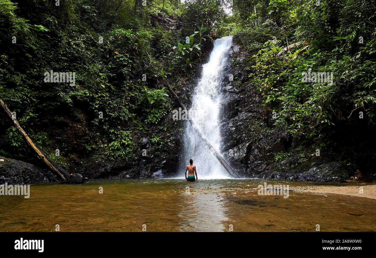 LANGKAWI, Malasia - Octubre 15.2019: Hombre tomar una ducha en .Durian Langawi Perangin cascada en la isla, Malasia Foto de stock