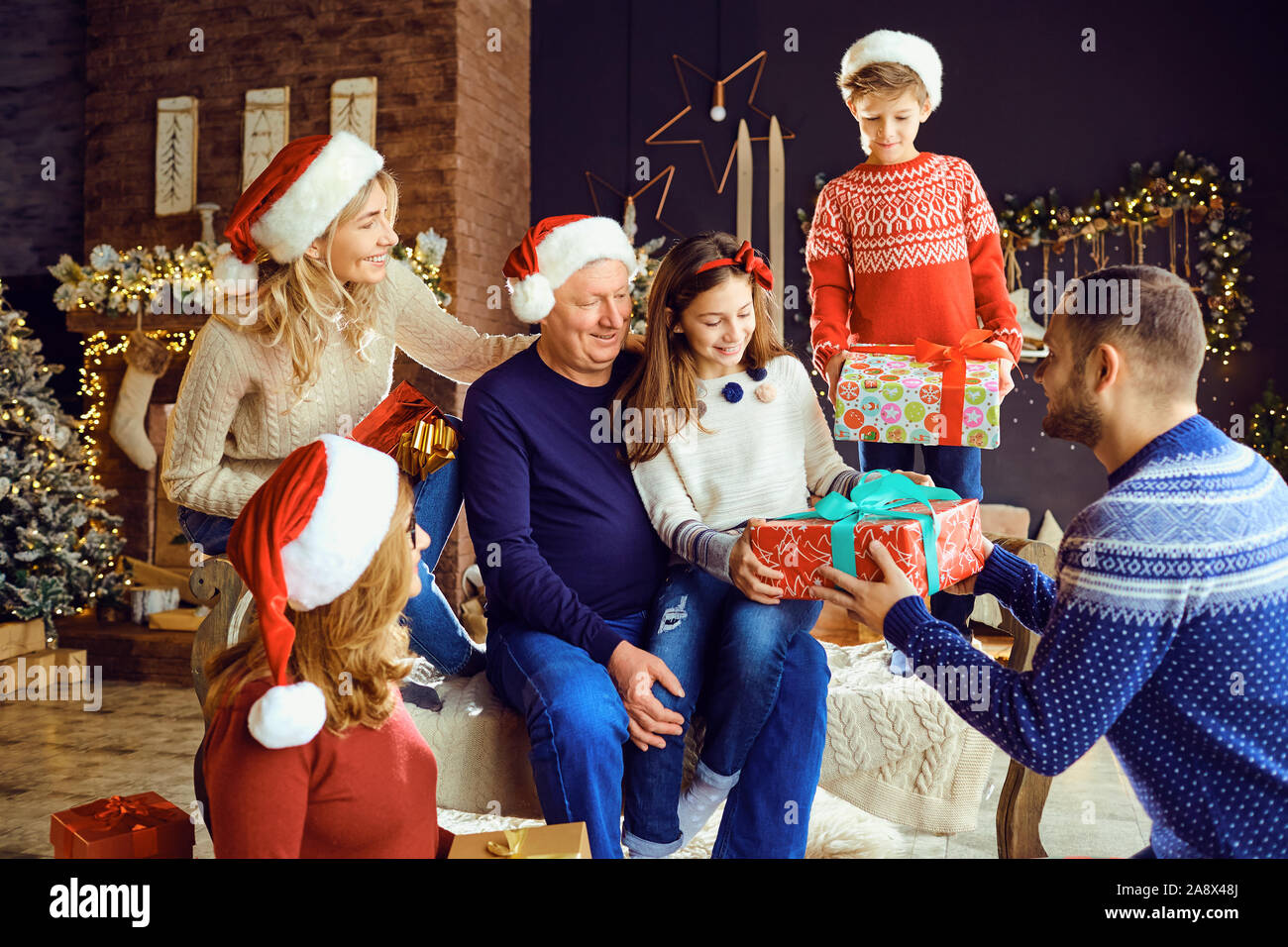 Una gran familia en una sala da regalos en Navidad. Foto de stock