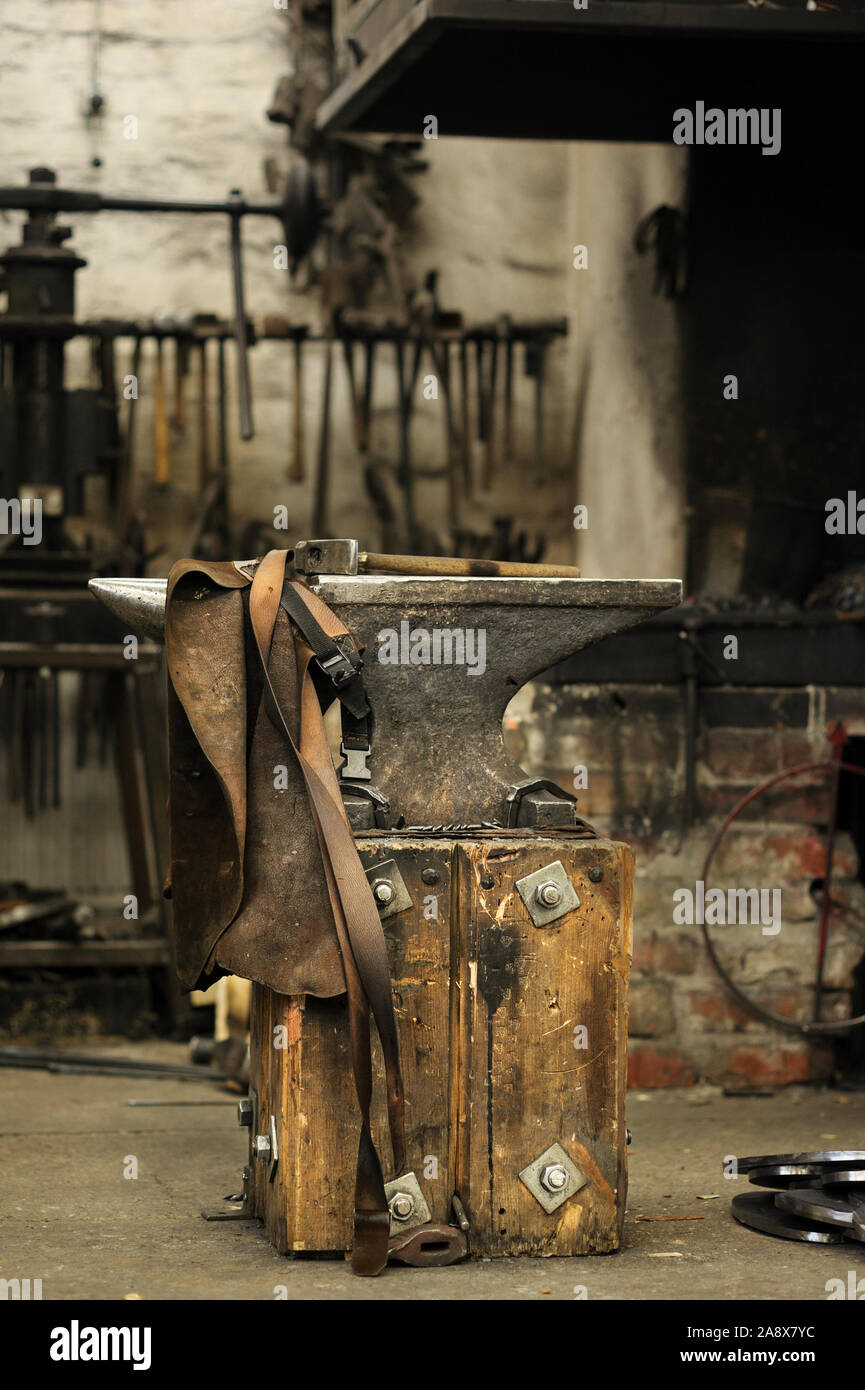 Yunque, martillo y delantal de cuero en herrería Fotografía de stock - Alamy