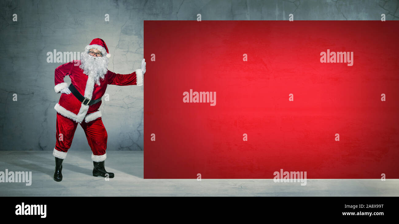 Santa Claus sosteniendo el banner de anuncio en blanco con espacio de copia. Tema de Navidad, ventas - Imagen Foto de stock